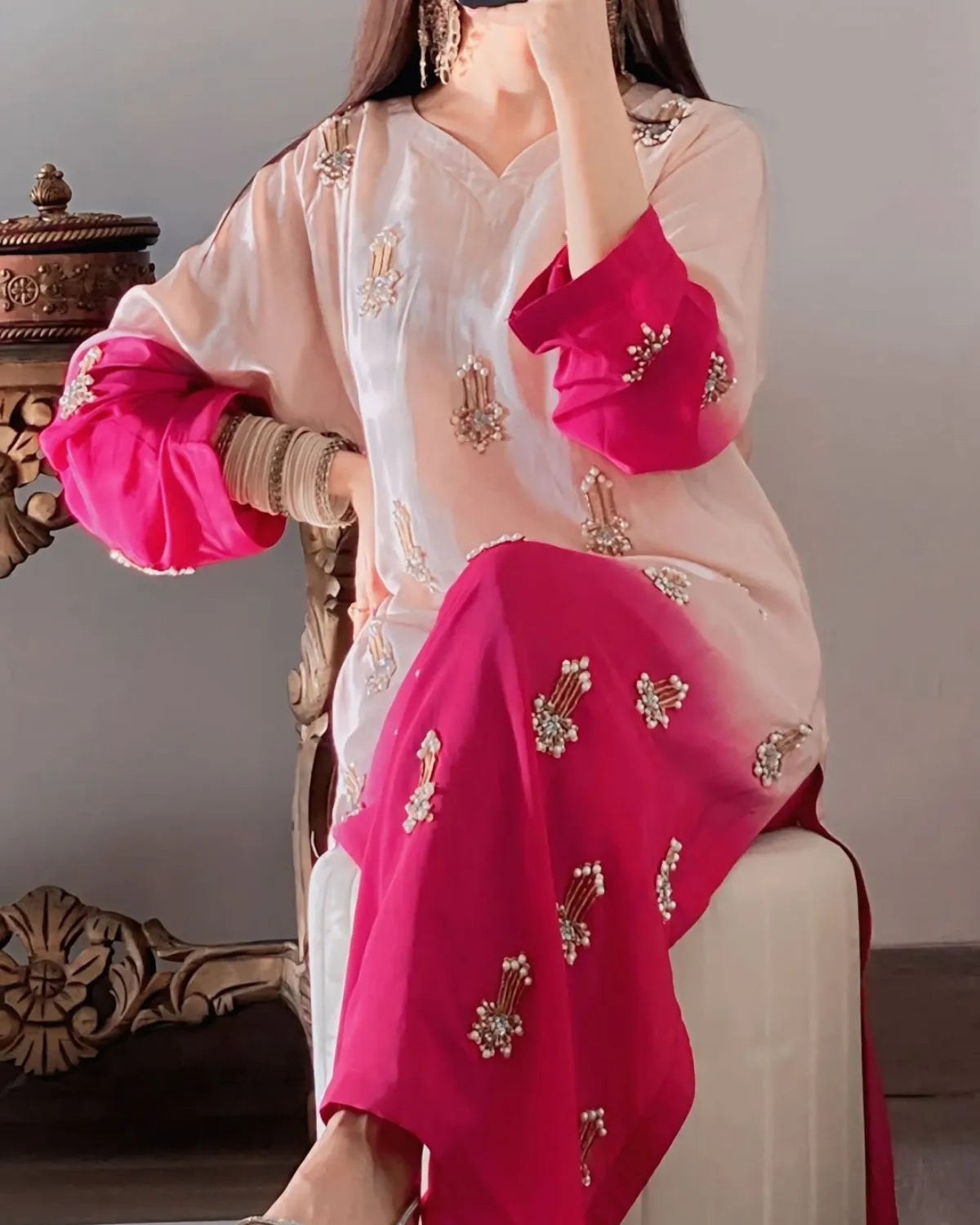 Woman wearing a traditional outfit with pink and white embroidery.