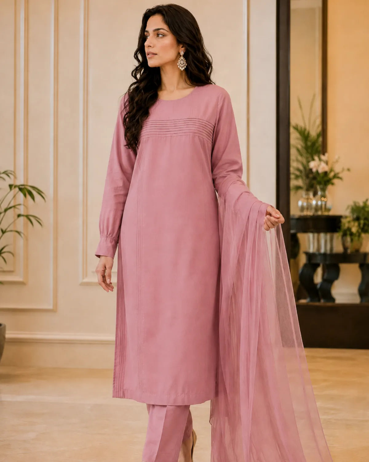 Woman in a pink traditional outfit standing in an elegant room.