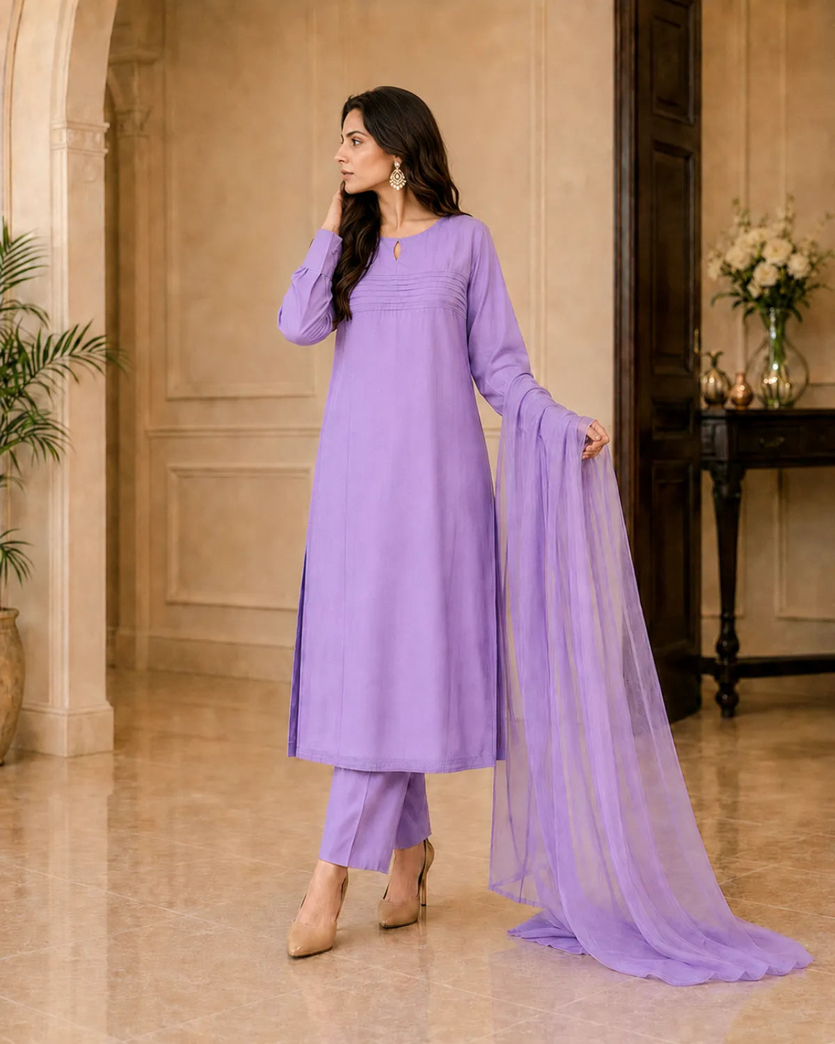 Woman in a lavender traditional outfit with a dupatta in an elegant indoor setting.