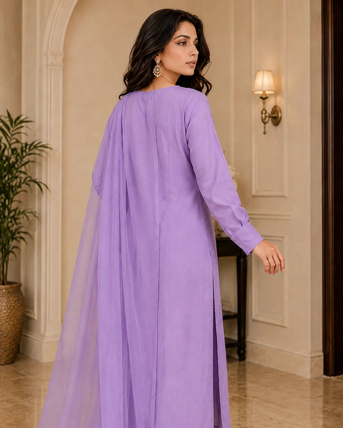 Woman wearing a long purple dress in an elegant interior setting