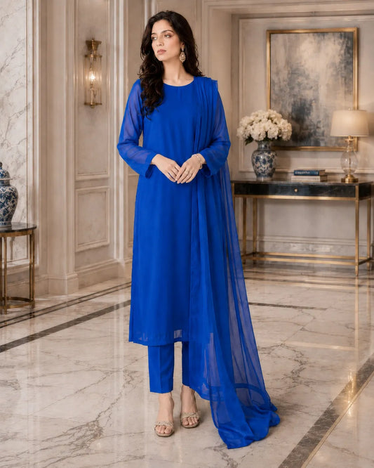 Woman in a blue outfit standing in an elegant interior setting